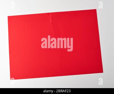 Déchiré à moitié vide en feuille de papier rouge sur fond blanc, Close up Banque D'Images