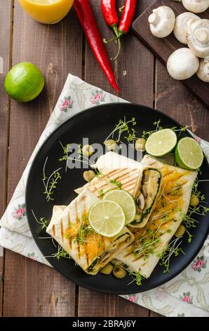 Petit-déjeuner burrito avec œufs, cheddar, microgreens, olives et champignons grillés Banque D'Images