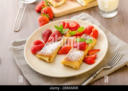 Blintzes - crêpes au fromage riccota rempli et creame fraîche avec des fruits frais et de menthe Banque D'Images