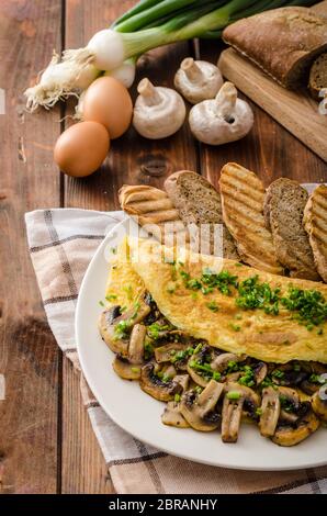 Omelette aux cèpes rustique à la ciboulette, rôtie de pain santé panini Banque D'Images