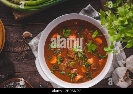 Ragoût de boeuf avec des carottes, de l'alimentation de la photographie, beaucoup d'herbes à l'intérieur de stew Banque D'Images