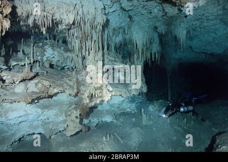 Sidemount plongeur technique nageant autour de formations de calcaire uniques dans le cenote Dreamgate au Mexique. Banque D'Images