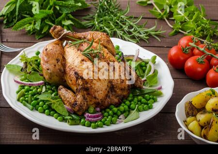Poulet grillé bio bio, pommes de terre, d'Herbes et légumes de printemps avec, avec de la bière Banque D'Images