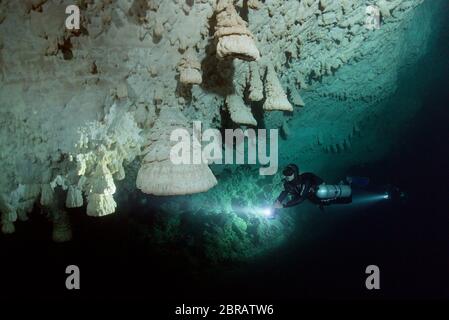 Le plongeur technique sidemount se balade le long du mur de Cenote Zapote, gouffre avec la magie des formations calcaires de Hells Bells au Mexique. Banque D'Images