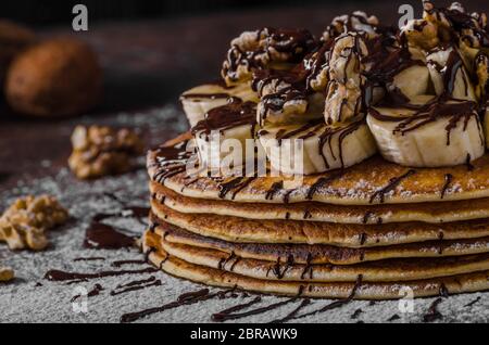 Crêpes avec rustique de banane et chocolat, noix grillées sur le dessus Banque D'Images