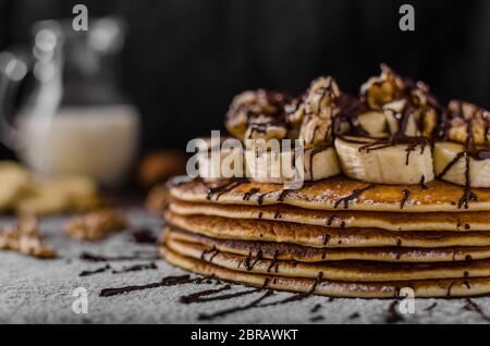 Crêpes avec rustique de banane et chocolat, noix grillées sur le dessus Banque D'Images