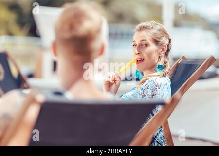 Femme à la plage mangeant de la popsicle tout en regardant son petit ami Banque D'Images