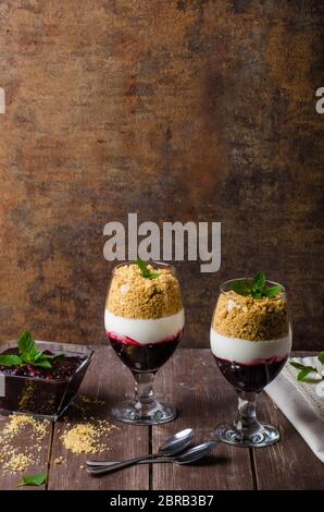 Dessert gâteau au fromage inversé dans le verre, délicieux et simple avec fruits frais et de biscuits avec la lumière creame. Banque D'Images