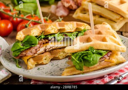 Sandwich avec du bacon, des gaufres et salade de poulet Banque D'Images