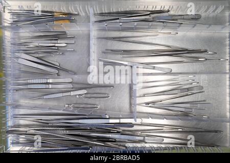différentes pinces chirurgicales se trouvent côte à côte dans un tiroir Banque D'Images