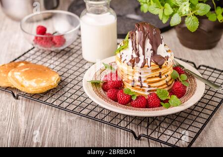 Crêpes américaines avec glace et chocolat, herbes et baies autour Banque D'Images