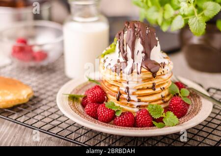 Crêpes américaines avec glace et chocolat, herbes et baies autour Banque D'Images