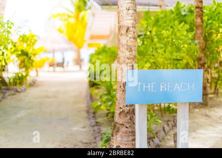 Panneau en bois sur le chemin tropical de la plage vers le restaurant extérieur et le bar de la plage Banque D'Images