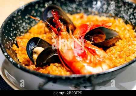 La Paella avec mariscos dans une casserole noire, un plat typique de la cuisine espagnole traditionnelle à base de fruits de mer et riz. Une cuisine traditionnelle Banque D'Images