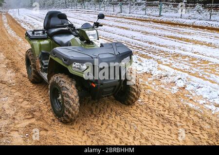 L'ATV se tient sur fond d'hiver à la frontière de l'État. Quad dans le sable. Quad en service à la frontière. Banque D'Images