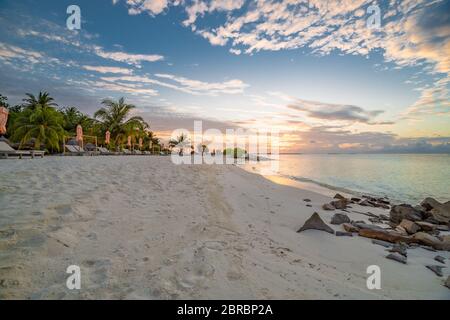 Paysage de plage d'été. Concept de vacances de luxe, bannière de voyage d'été. Paysage panoramique de plage au coucher du soleil, deux chaises longues, parasols Banque D'Images
