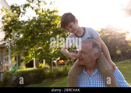 Grand-père et petit-fils à la maison dans leur jardin Banque D'Images