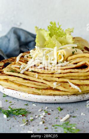 Lefse norvégien les galettes de pommes de terre sur un fond clair avec du fromage et des verts. Une cuisine traditionnelle scandinave. Banque D'Images