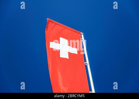 Drapeau national suisse devant le ciel bleu, canton de Zurich, Suisse Banque D'Images