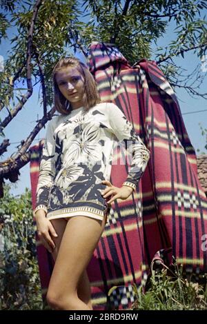 jeune femme mince posant dans le jardin portant une robe miniature tendance années 1970 hongrie Banque D'Images