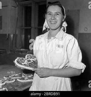 femme souriante de boulangerie tenant le pain d'épice en forme de coeur années 1950 hongrie Banque D'Images
