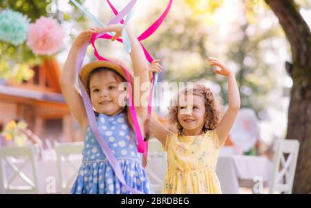 Petites filles jouant à l'extérieur dans le jardin en été, concept de célébration d'anniversaire. Banque D'Images