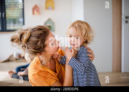 Jeune mère avec petite fille à l'intérieur dans la chambre à coucher parlant. Banque D'Images