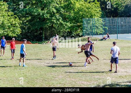 Un groupe de jeunes hommes qui ignorent les règles de distanciation sociale pour jouer au football à Waterlow Park pendant le confinement en cas de pandémie du coronavirus, dans le nord de Londres, au Royaume-Uni Banque D'Images