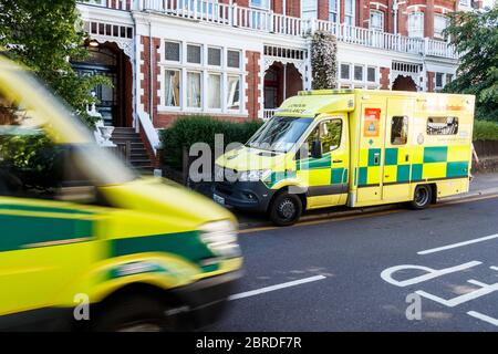 Une ambulance d'urgence se rend à une adresse résidentielle tandis qu'une autre s'accélère pendant le confinement en cas de pandémie du coronavirus, à North London, au Royaume-Uni Banque D'Images