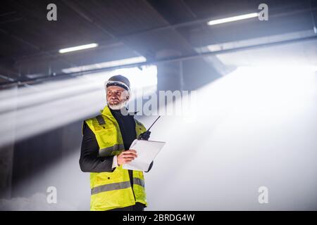 Un ingénieur utilise un talkie-walkie sur le chantier. Banque D'Images