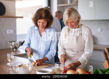 Groupe d'amis senior à dîner à la maison, cuisine. Banque D'Images
