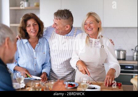 Groupe d'amis senior à dîner à la maison, cuisine. Banque D'Images