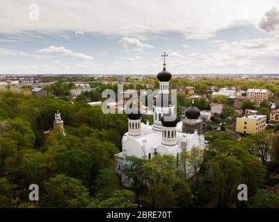 Église orthodoxe parmi avec arbre vert et ciel bleu ciel nuageux Banque D'Images