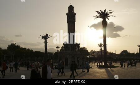 Izmir, Turquie - 10 juillet 2017 : les gens sur la place Konak près de l'historique avec la silhouette de la tour d'horloge d'izmir au coucher du soleil. Banque D'Images