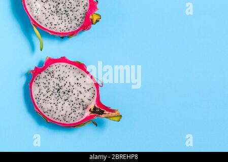 Des tranches de Pitaya ou pitahaya gros plan sur fond bleu avec une copie de l'espace. Pitaya espèce Hylocereus undatus. Fruits d'été mûrs Banque D'Images