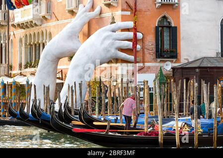 Venise, Italie - 18 mai 2017 : des mains géantes montent de l'eau du Grand Canal pour soutenir le bâtiment. Ce puissant rapport sur le changement climatique de Banque D'Images