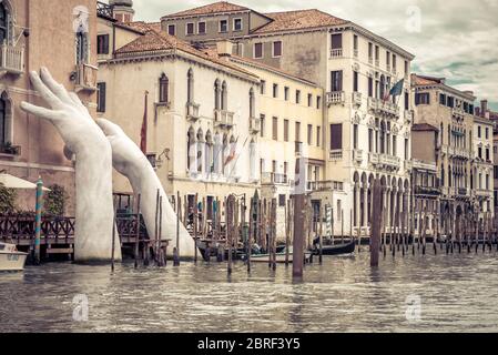 Venise, Italie - 21 mai 2017 : des mains géantes s'élèvent de l'eau du Grand Canal pour soutenir le bâtiment. Ce rapport puissant sur le changement climatique de Banque D'Images