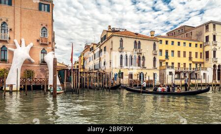 Venise, Italie - 21 mai 2017 : des mains géantes s'élèvent de l'eau du Grand Canal pour soutenir le bâtiment. Ce rapport puissant sur le changement climatique de Banque D'Images