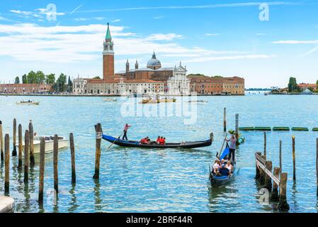 Venise, Italie - 21 mai 2017 : des gondoles avec des touristes naviguent le long de la lagune vénitienne. San Giorgio Maggiore en arrière-plan. La gondole est la Banque D'Images