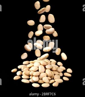 Tas de haricots blancs isolés sur fond noir Banque D'Images