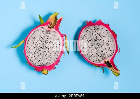 Le fruit de Pitaya. Deux moitiés de pitahaya mûr et doux. Gros plan sur un fond bleu. Arrière-plan d'été lumineux. L'été. Un vi haut Banque D'Images