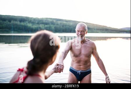 Couple senior en maillot de bain debout dans le lac à l'extérieur avant de nager. Banque D'Images