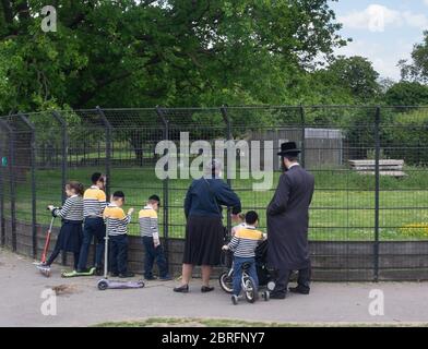 Une famille de Juifs hassidiques ou Haredi, dont cinq enfants, se rend au parc Clissold de Stoke Newington, dans le nord de Londres, pendant l'isolement de 2020 Banque D'Images