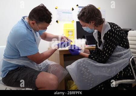 Katy Peters, de la London vaccine Clinic, présente une trousse de test d'anticorps IgG anti-COV-2 à domicile, sur le client David Barton, un avocat de Capital Markets âgé de 49 ans, à Notting Hill, Londres, alors que le Royaume-Uni continue de se maintenir en isolement pour aider à freiner la propagation du coronavirus. Banque D'Images