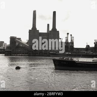 Dans les années 1950, photo de Battersea Power Station, une centrale électrique fonctionnant au charbon, qui ne disposait que de trois de ses fameux chmineys à l'époque, la quatrième devait encore être ajoutée. L'extérieur du célèbre bâtiment en briques a été conçu par Sir Giles Gilert Scott, un architecte distingué qui a conçu le coffret téléphonique rouge et la cathédrale de Liverpool, ainsi que Bankside. La station A originale de Battersea a été achevée en 1935. La construction de l'après-guerre a commencé à la deuxième phase, la station B, avec deux cheminées un miroir de la STATION A et ils sont entrés en service entre 1953 et 55. Banque D'Images