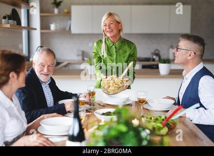 Groupe d'amis senior au dîner à la maison. Banque D'Images