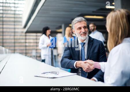 Les médecins qui s'en sont parlé à un représentant des ventes pharmaceutiques, se serrer la main. Banque D'Images