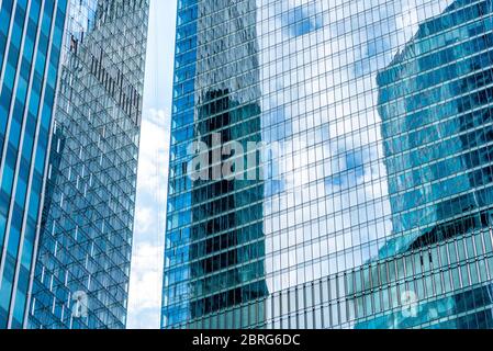 Le ciel et les bâtiments se reflètent dans un gratte-ciel moderne. Contexte et concept de l'architecture et de la finance modernes. Banque D'Images