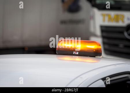 Témoin orange sur un véhicule d'entretien traversant des travaux routiers en Angleterre, au Royaume-Uni. Banque D'Images