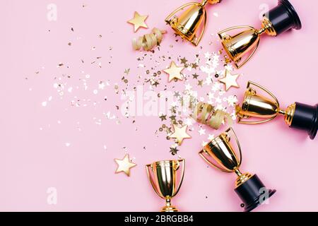 Coupes Golden Winner avec des taches sur un fond rose avec espace de copie. Concept festif. Style plat. Banque D'Images